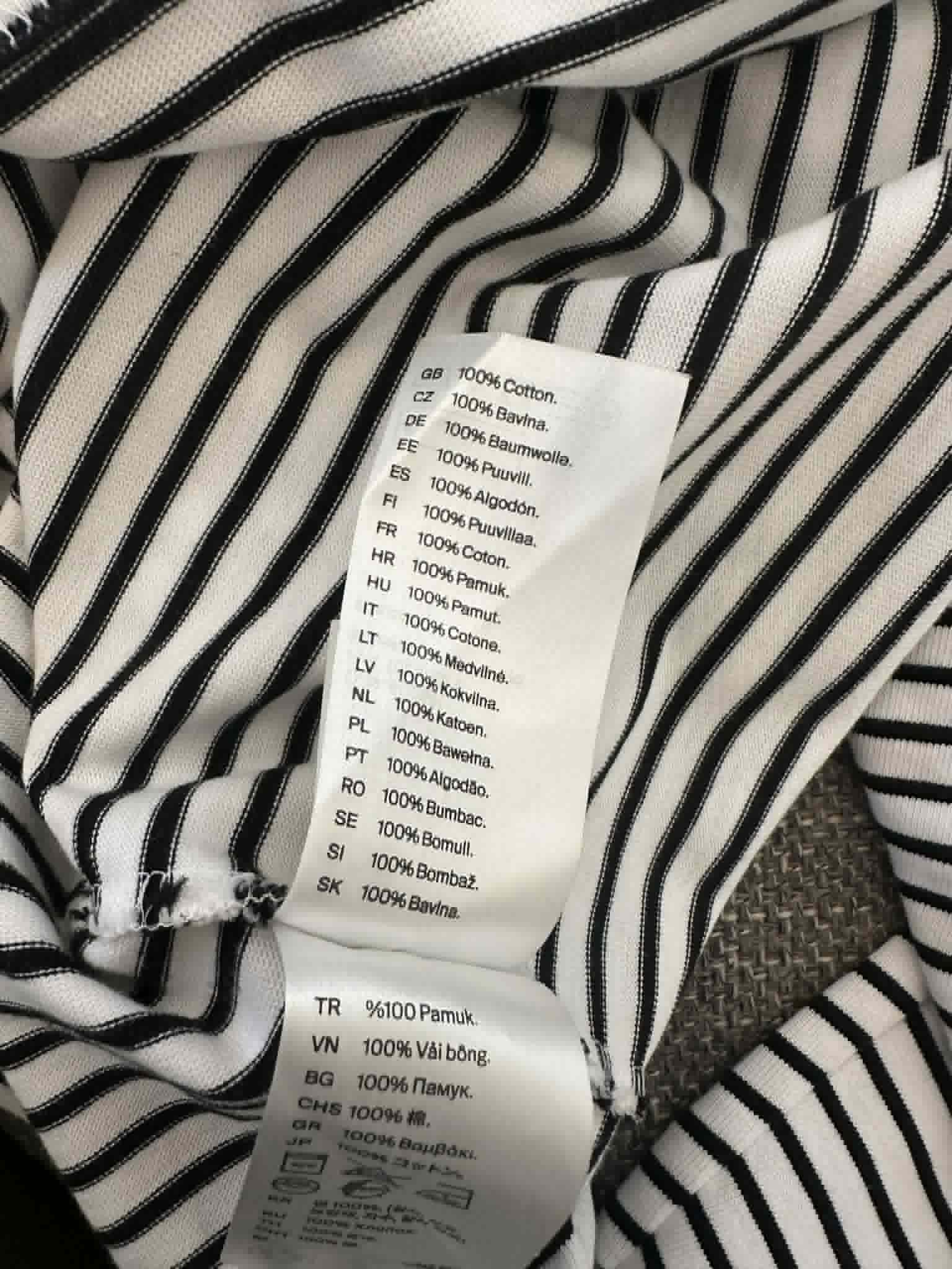 COS care label showing 100% cotton composition in multiple languages
