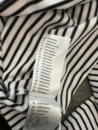COS care label showing 100% cotton composition in multiple languages